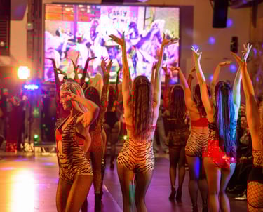 Dancers in tiger print costumes perform on a stage during a vibrant event venue in downtown Austin