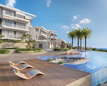 Luxury modern villa with an infinity pool, sun loungers, and ocean views under a blue sky.