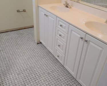 Bathroom remodel with dual-sink vanity,marble-look tile flooring and sleek fixtures—combining funcio