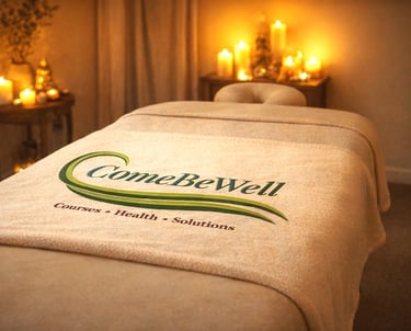 Candlelit healing room with a massage table draped in softness, inviting rest and renewal
