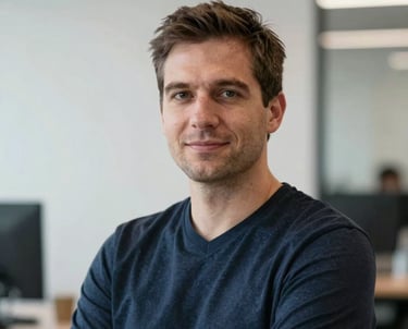 Portrait of a technology lead with a focused and professional expression. North American office setting with clean, white walls and a blurred tech background.