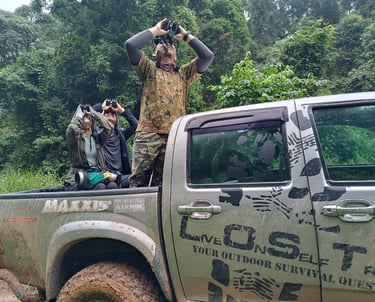 a man in camouflage gear is guiding tourist looking at wildlife 