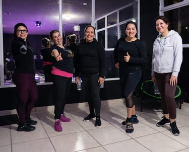 Grupo diverso de mujeres posando y sonriendo después de un entrenamiento