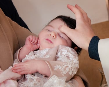 mala beba spava dok ju svećenik blagoslovi