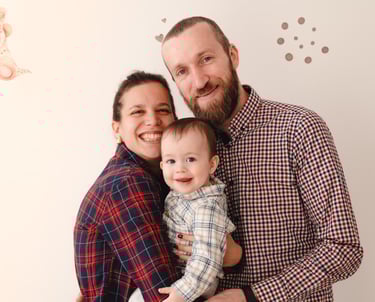 sretna obitelj koja drži svoju bebu