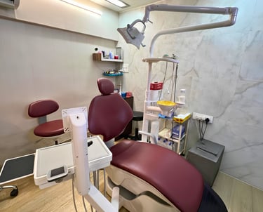 Modern dental clinic interior featuring a maroon leather examination chair and advanced medical equipment.
