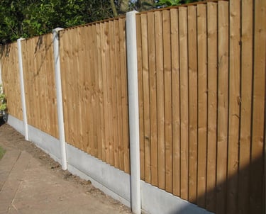 A long boundary fence, concrete posts and gravel boards fitted with Pillar to Post fence panels