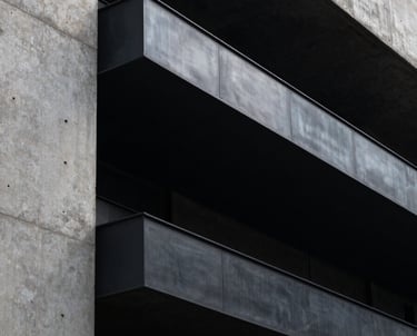 Modern urban South American architectural detail, black steel and concrete, moody shadows, minimalist and powerful.