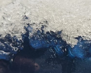 close up picture of ice melting off a blue metal surface