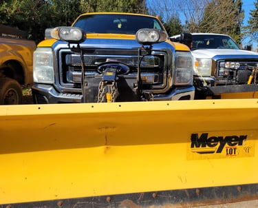 the front of a yellow truck with a yellow meyer plow blade on it
