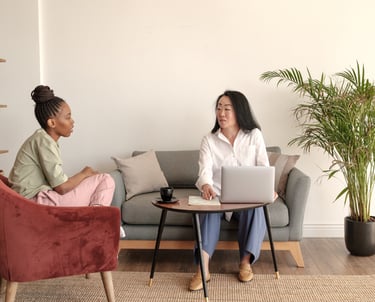 two women sitting on a couch in a living room