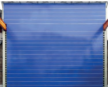 Large blue industrial high-speed fabric roll-up door for warehouse and hangar access.