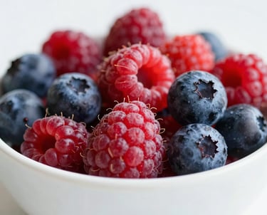 Close-up of colorful, fresh berries in a white ceramic bowl, representing conscious nutrition and attention to detail, soft and airy aesthetic.