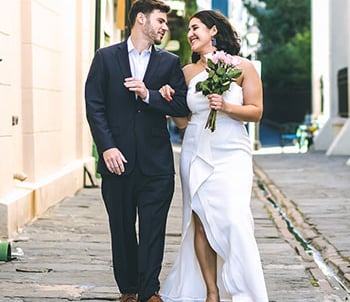 a bride and groom walking down a narrow alley near St Louis cathedral in New Orleans