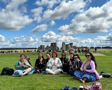 Grupo de mujeres en pose de meditación cerca Stonehenge
