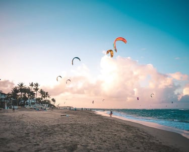 a beach with people flying kites and kites in cabarete dominican republic