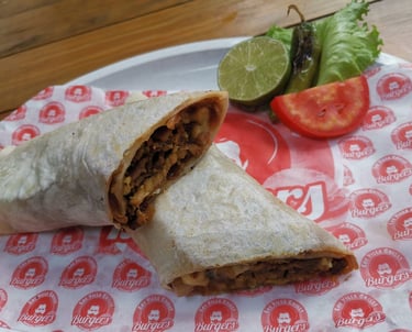 Un burrito de bistec al estilo mexicano, cortado en rebanadas y servido con lima, jalapeño y tomate 