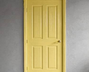 Professional painter applying white paint on apartment wall with protective floor covering in Porto Alegre.