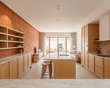 Modern open-plan kitchen with wooden cabinets, marble island, and plaster-finished walls