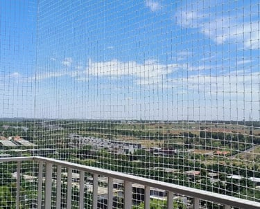 Technicians from Arjilli Safety Nets fitting a custom balcony net with precision tools.