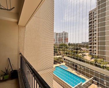 Wide shot of a high-rise balcony in Vasai with a neatly installed pigeon net.