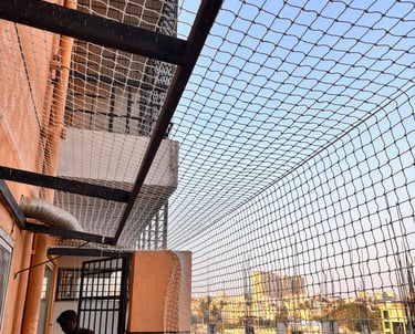 Wide shot of a Colaba apartment balcony fully covered with a neatly installed safety net.