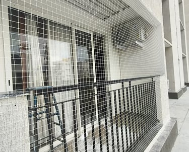 Wide shot of a residential building in Thane East featuring newly installed safety nets on all balco