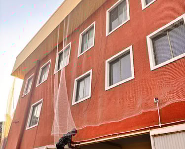 Wide shot of a high-rise Powai apartment complex fitted with seamless pigeon nets on all balconies.