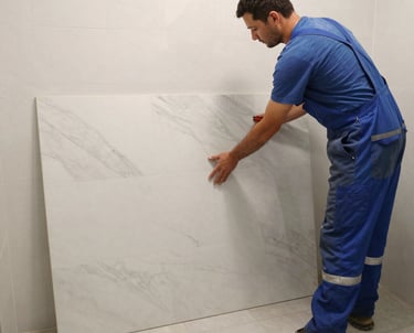 Close-up of hands installing elegant tile work in a shower area.