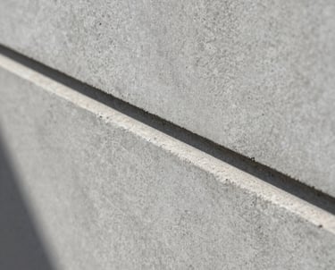 Macro shot of concrete texture with a sharp shadow line, representing the minimalist and professional brand identity, medium gray.