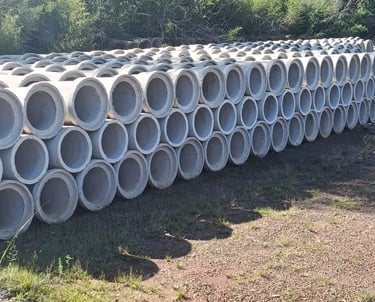 Stacked concrete drainage pipes for civil engineering and infrastructure projects outdoors.