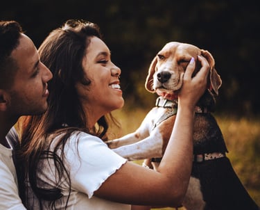 una pareja lfeliz sentada con perrito beagle