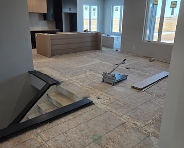 Modern home kitchen under construction with plywood subflooring and a laminate floor cutter tool.