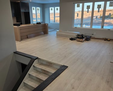 New light oak luxury vinyl plank flooring installed in a modern home interior under renovation.