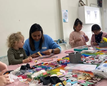 Niñas pequeñas y una maestra disfrutan de un taller creativo