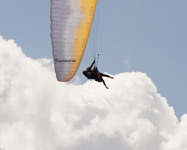 Pilota in volo con parapendio sopra le nuvole, esperienza di volo libero nella natura vicino a Rieti