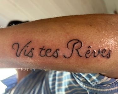 Tatouage phrase inspirationnelle Vis tes rêves en lettrage script fin