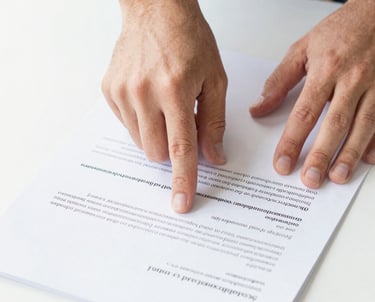 Close-up of Henrique Staron reviewing mechanical blueprints in a bright office.