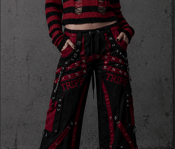 Woman wearing gothic Tripp NYC bondage pants and a red striped distressed sweater.