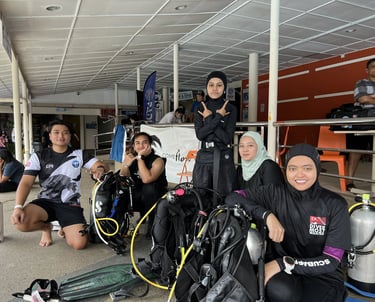 a group of people standing around a group of scuba divers