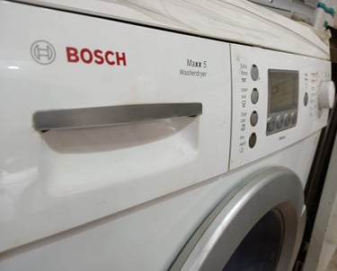 White Bosch Maxx 5 front-loading washer dryer featuring digital display and setting buttons.