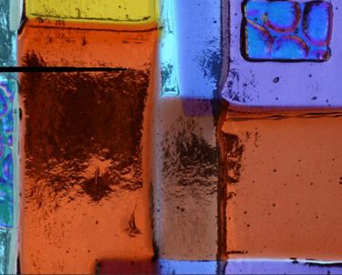 Colorful fused glass art with reds, oranges, greens and yellows