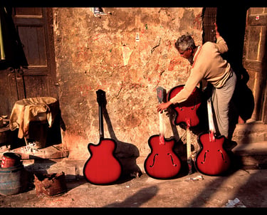 Freshly painted guitars dry outside the craftman's workshop in Kolkata, India.