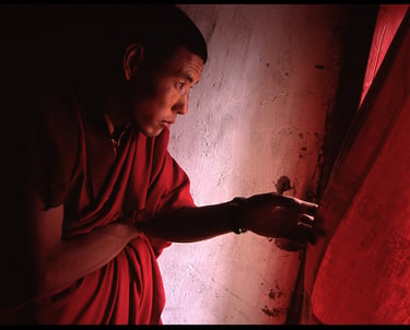 A monk looks out the window of the monastery in Leh, Ladakh.
