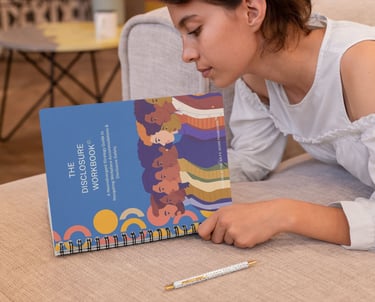 A woman reads The Disclosure Workbook, a neurodivergent strategy guide for workplace accommodations.