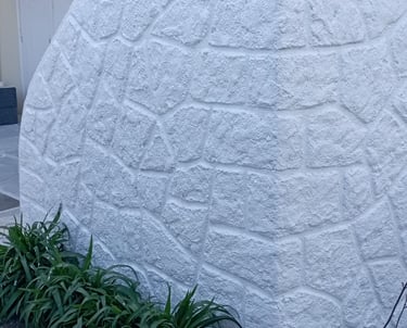 a large white rock wall with a large rock wall