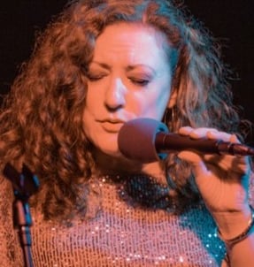 Close-up of Singer Nancy Erickson Lamont's expressive face as she sings into the microphone