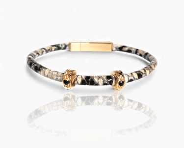Luxury snakeskin leather bracelet featuring gold charms with black gemstones on a white background.
