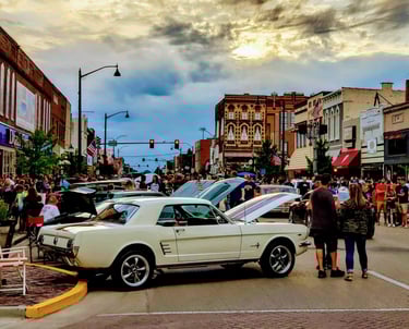Vintage Ford Mustang at a crowded outdoor classic car show on a historic downtown streator IL