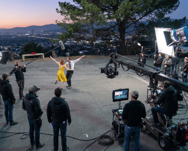 Professional video production set showcasing cinematic lighting, camera rigs, and a creative team ca